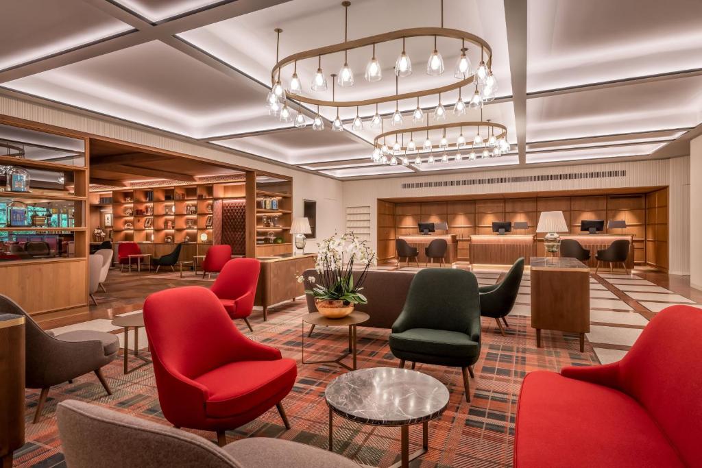 a lobby with red chairs and a waiting room at Sheraton Grand Salzburg in Salzburg