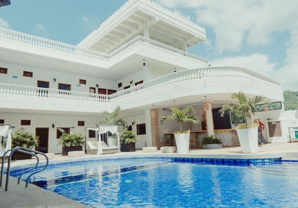 a hotel with a swimming pool in front of a building at Hotel Abitti in Taganga