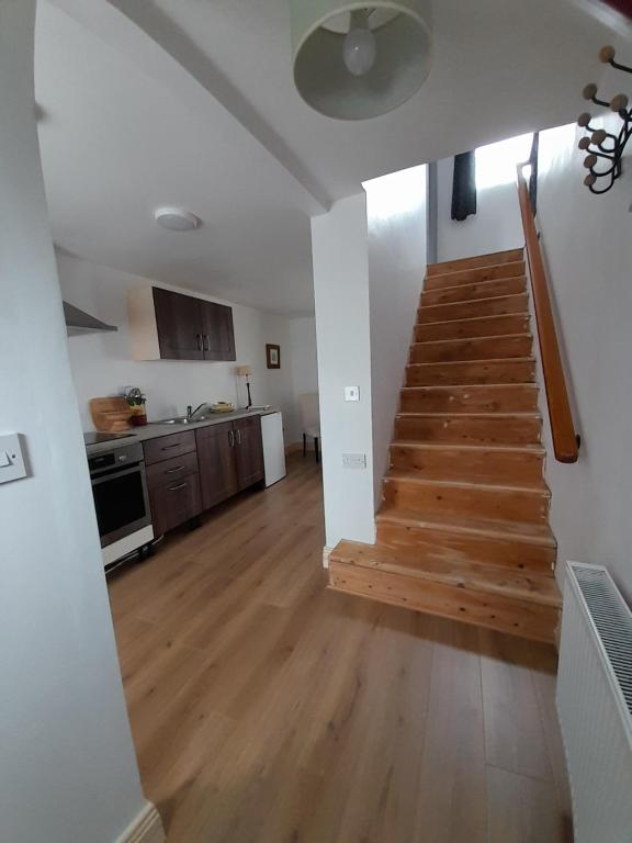 a living room with a staircase and a kitchen at Central Town Apartment in Wexford