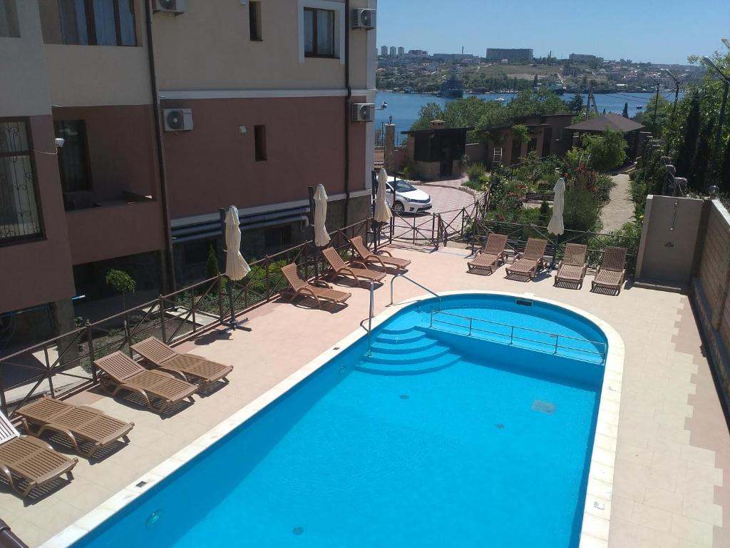 una piscina con tumbonas y un edificio en Villa Venezia en Sevastopol