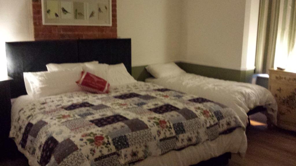 a bedroom with a bed with a quilt on it at The Railway Inn Westerfield in Ipswich