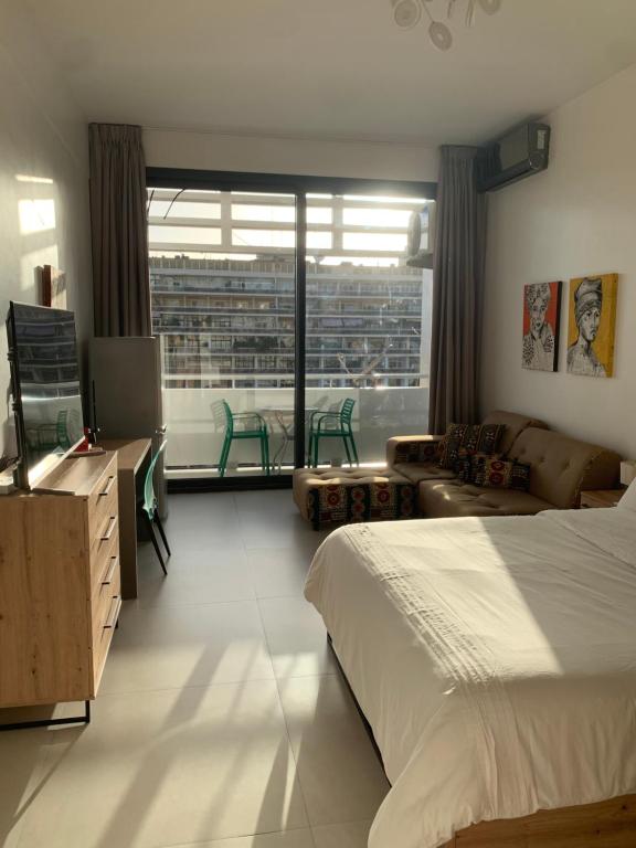 a bedroom with a bed and a living room at CHEZ RIMA // Studio très chaleureux F1 // Très bien situé in Dakar