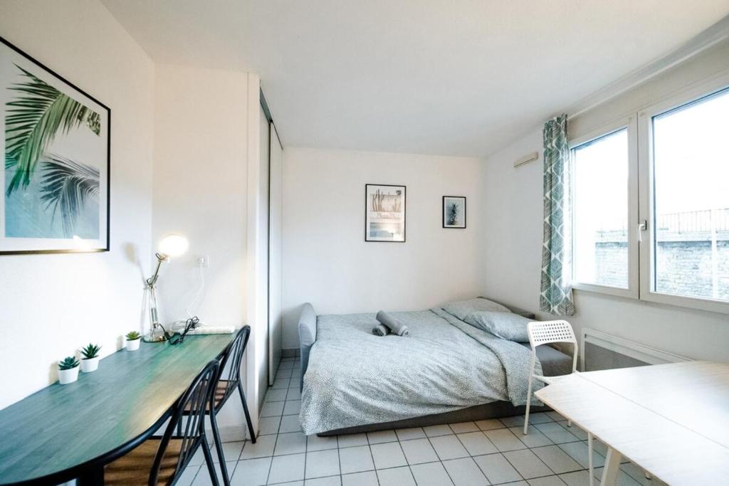 a bedroom with a bed and a table in it at Le petit Gilibert - studio cosy 2 pers - Perrache in Lyon