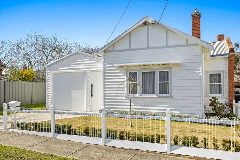 una casa blanca con una valla delante en Duc De Malakoff en Ballarat