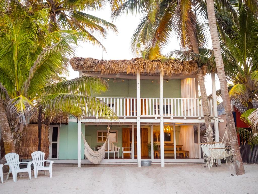 a house on the beach with chairs and palm trees at Utopia Guesthouse & Yoga Studio beachfront home in El Cuyo