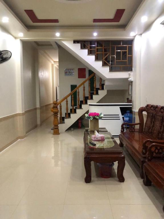 a living room with a couch and a table and stairs at Holly's Hostel Ha Giang B&B in Ha Giang