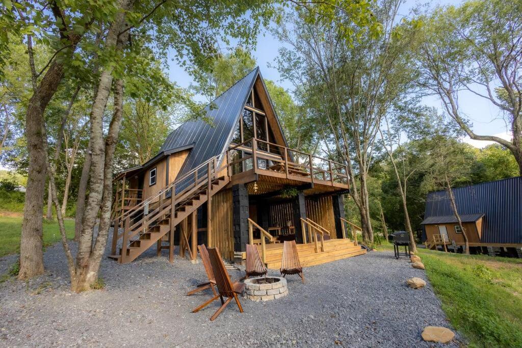 een grote houten hut in het bos met een terras bij Valhalla Cabins AFrames with hot tubs in Cosby
