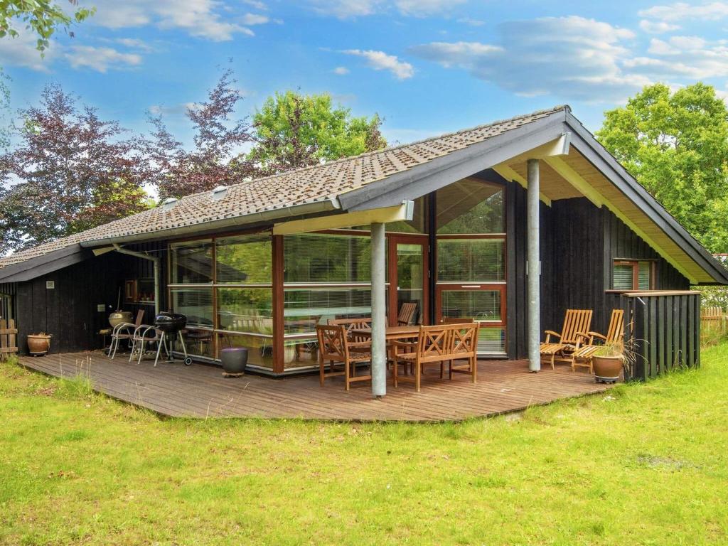 a house with a deck with a table and chairs at 8 person holiday home in Glesborg in Glesborg