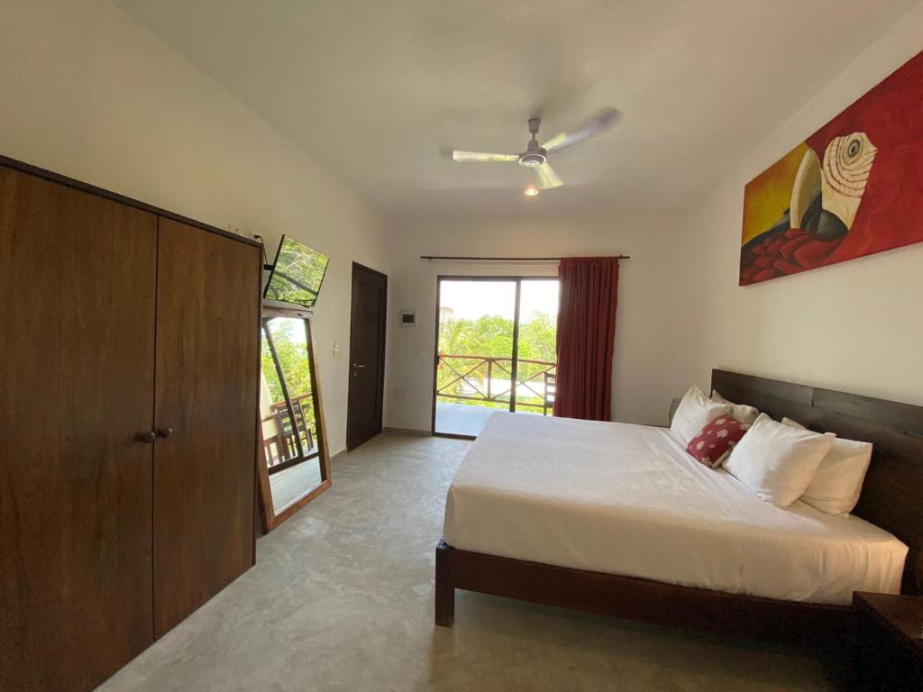a bedroom with a bed and a sliding glass door at Basic Tulum in Tulum