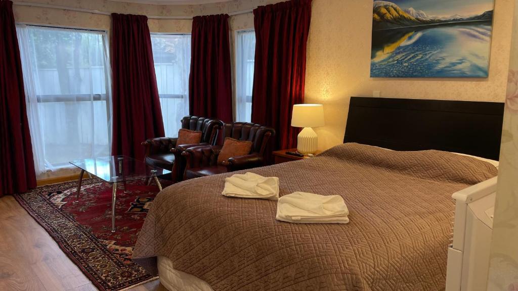 Pokój hotelowy z łóżkiem i krzesłem w obiekcie Cascades Motor Lodge w Auckland