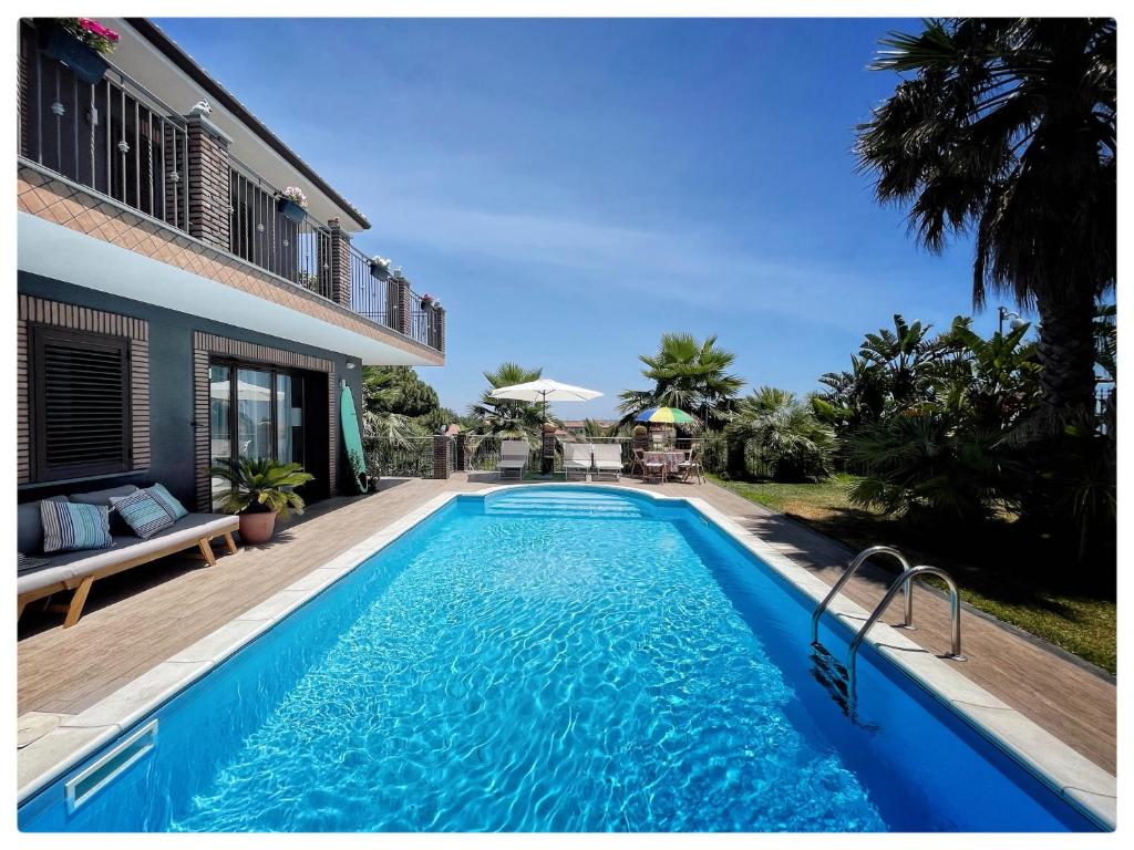 a swimming pool in front of a house at Etna Pool Jacuzzi Villa -Sea view & Mt Etnaa in Mascalucia