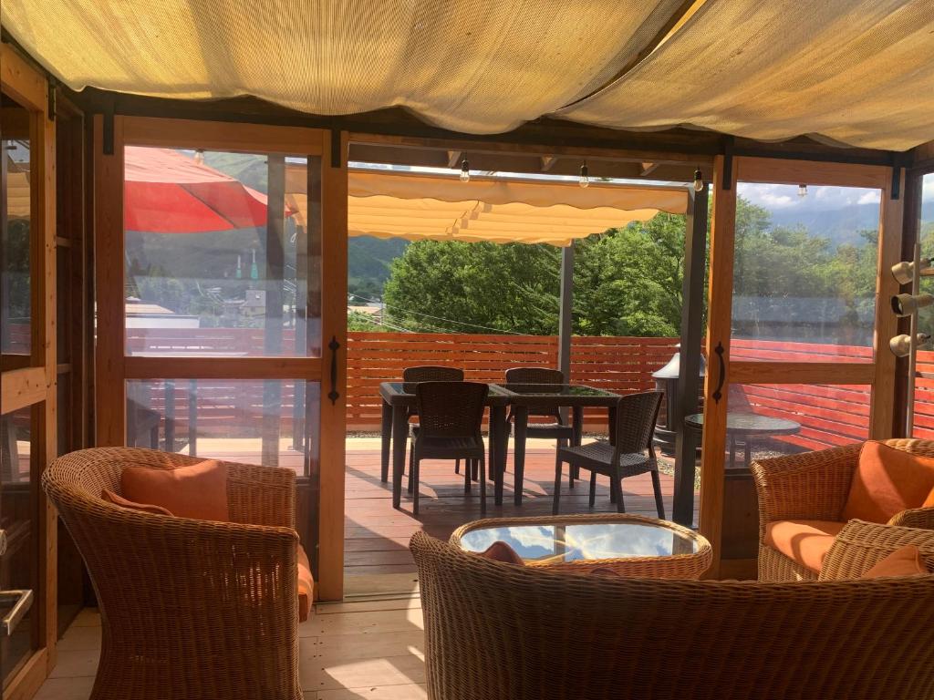 une terrasse avec une table, des chaises et un parasol dans l'établissement Hakuba Ski Condos, à Hakuba