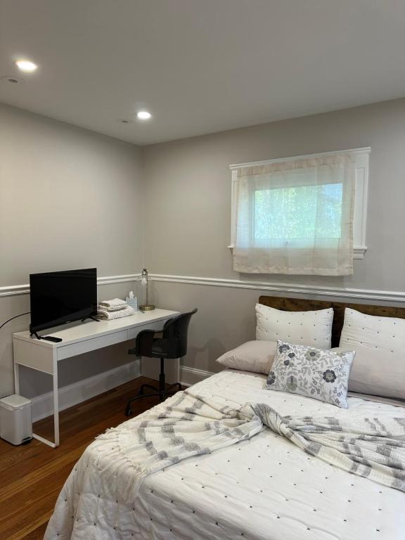 a bedroom with two beds and a desk with a computer at Charming Room in Boston