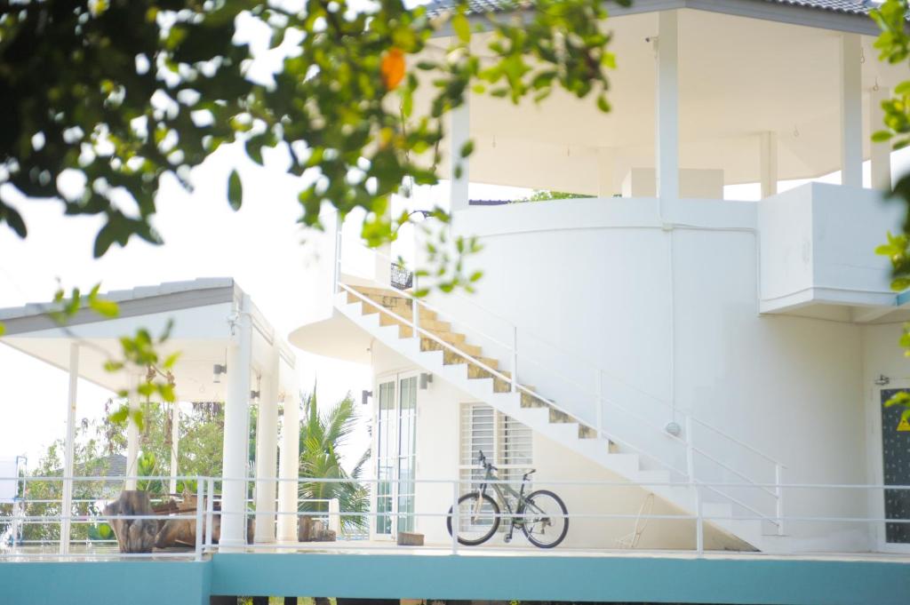 a bike parked on the side of a white house at Bayfront608 in Ban Khlong Dan