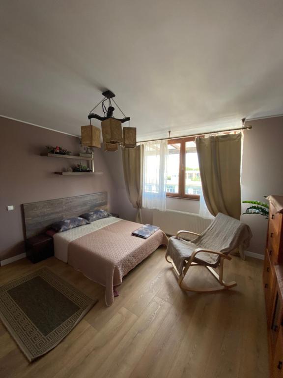 een slaapkamer met een bed, een stoel en een raam bij Seawave Black Sea Coast in Constanţa