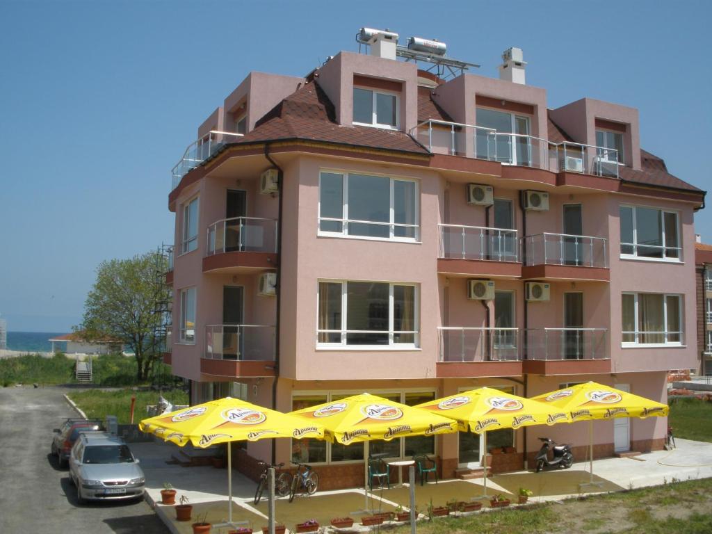 a building with yellow umbrellas in front of it at Hotel Paradise in Lozenets