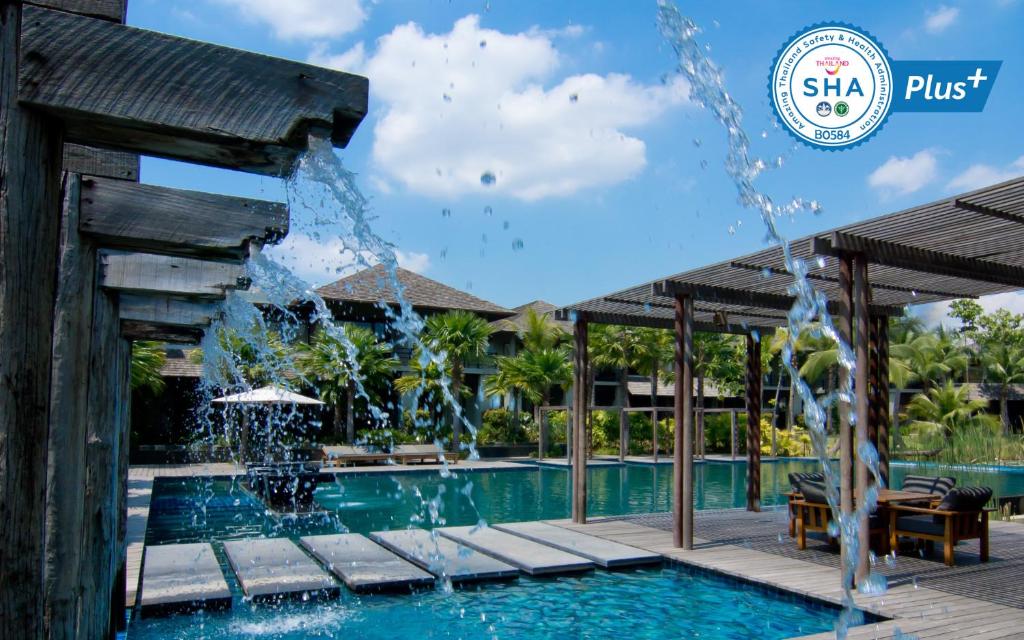 a pool at a resort with a water fountain at Pattara Resort & Spa in Phitsanulok
