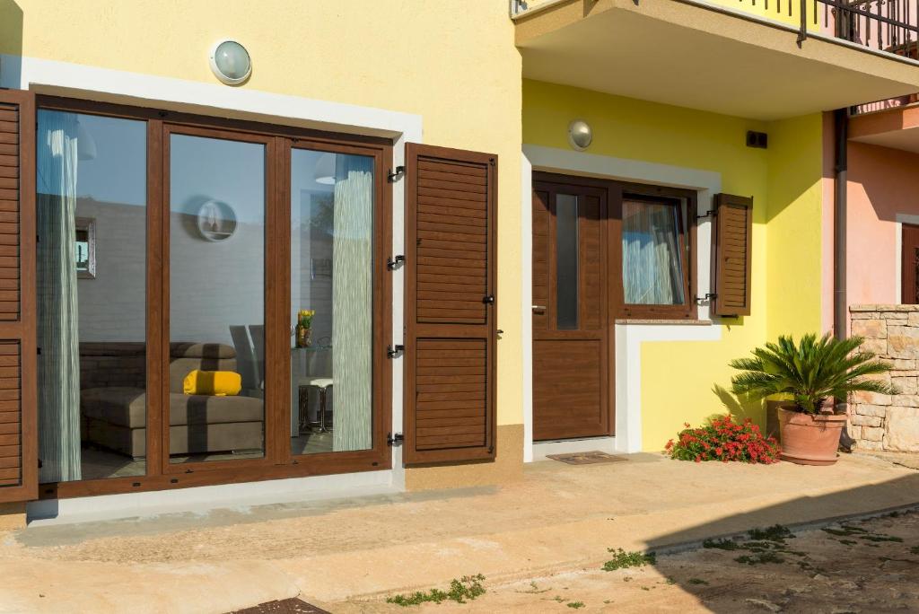 a house with wooden doors and a patio at Apartman Paštura in Vodnjan