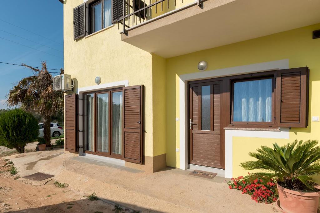 dom z drewnianymi drzwiami i balkonem w obiekcie Apartman Paštura w mieście Vodnjan
