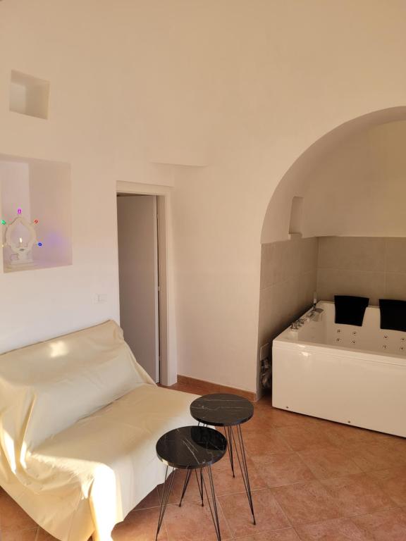 um quarto com uma cama, duas mesas e uma banheira em Trullo il Gelso em San Michele Salentino