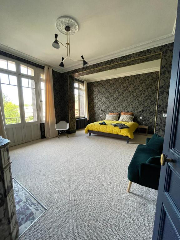 a bedroom with a bed and a yellow bedspread at Maison Mandarine in Bellerive-sur-Allier