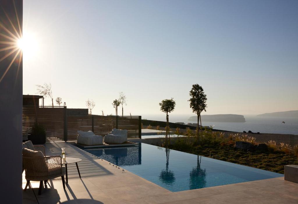 a swimming pool with a view of the water at Aernia Suites & Art in Akrotiri