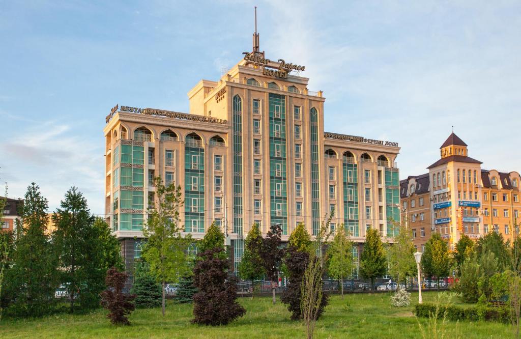 un grand bâtiment avec un champ devant lui dans l'établissement Bilyar Palace, à Kazan