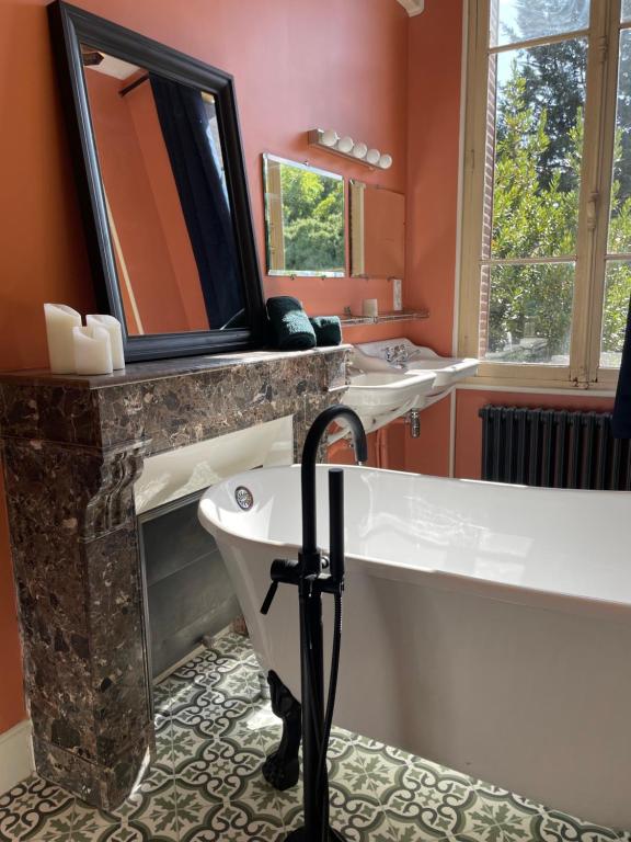 La salle de bains est pourvue d'une baignoire, d'un lavabo et d'une baignoire. dans l'établissement Maison Mandarine, à Bellerive-sur-Allier