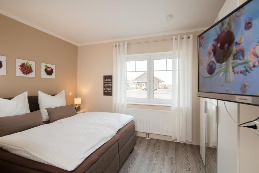 a bedroom with a bed and a flat screen tv at Fewo Obsthof Matthies in Jork