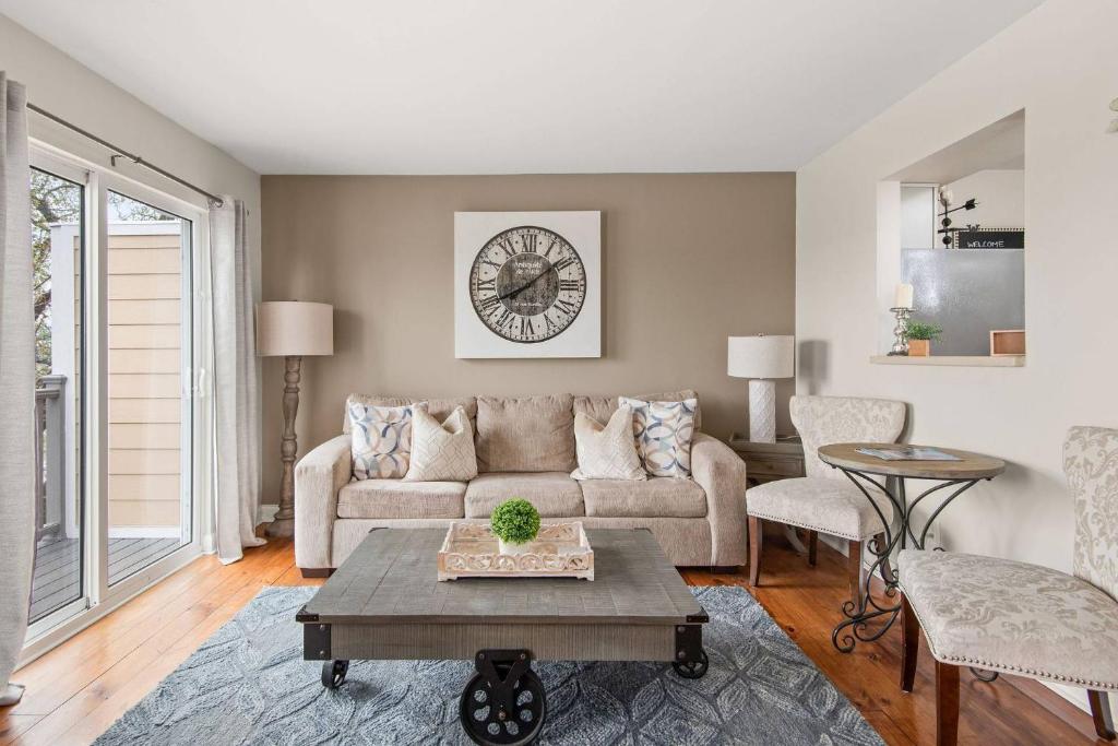 ein Wohnzimmer mit einer Couch und einer Uhr an der Wand in der Unterkunft Riverfront 786 in Nashville