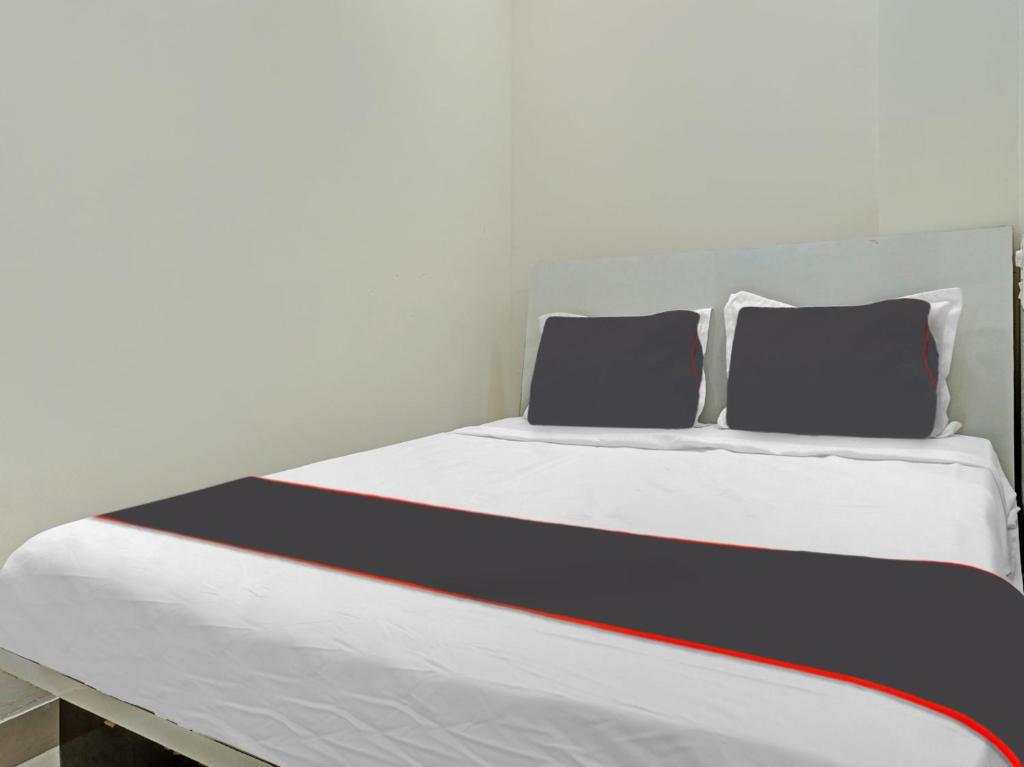a bed with two pillows on top of it at Collection O Brahma Residency in Chinchiwad