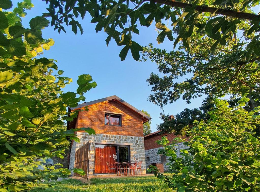 una vieja casa de ladrillo vista a través de los árboles en Lura Agroturizem, en Novoberdo