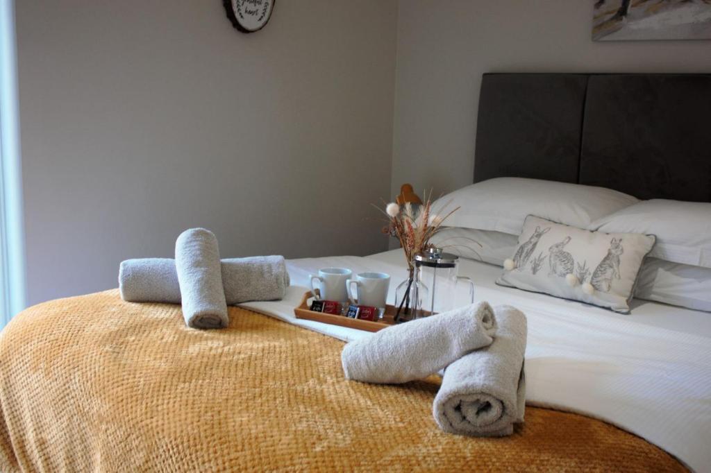 1 dormitorio con 1 cama con toallas en The Squirrels- Alresford, Essex en Alresford