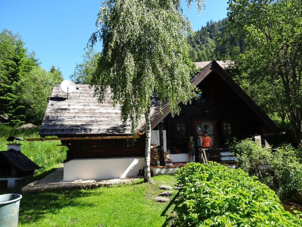 dom z drzewem przed nim w obiekcie Fischerhütte Donnersbachwald w mieście Donnersbachwald