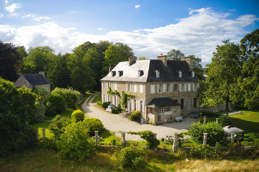 uma propriedade com uma casa grande com uma entrada em Les chambres d'hôtes du Manoir de Roz-Maria em Quintin