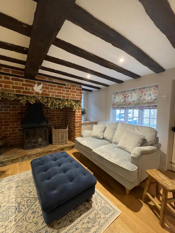 ein Wohnzimmer mit Couch und Kamin in der Unterkunft Historic Cambridgeshire Cottage in Godmanchester