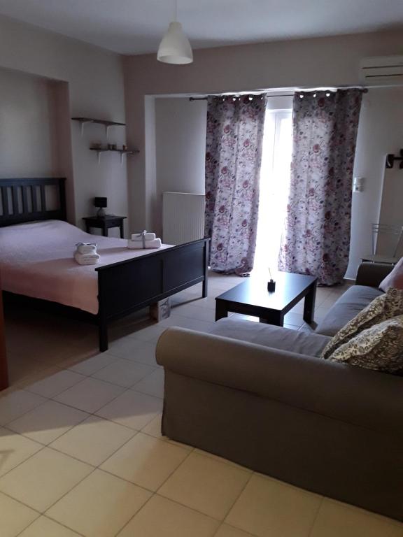 ein Wohnzimmer mit einem Sofa, einem Bett und einem Fenster in der Unterkunft G3 sea view appartment in Igoumenitsa