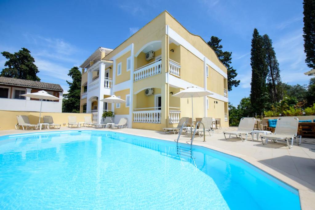 a large swimming pool in front of a house at Saint Spiridon Hotel in Kassiopi