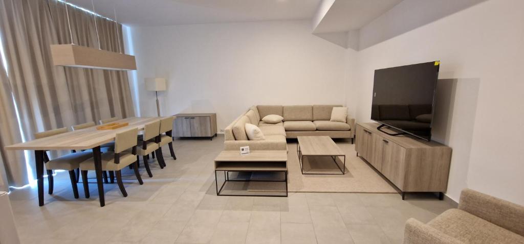 ein Wohnzimmer mit einem Sofa, einem Tisch und einem TV in der Unterkunft iComfort Aparthotel in Timişoara