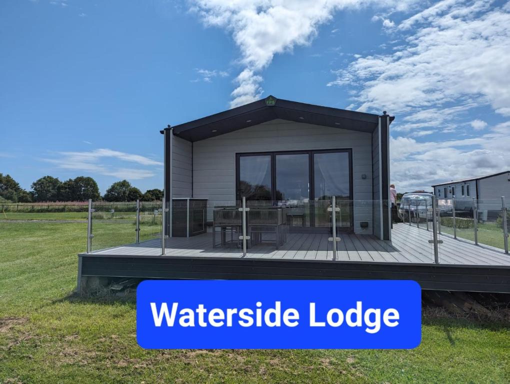 a building with a water pesticide lodge on a field at Waterside Lodge - Stunning - Dog Friendly in Sutton on Sea