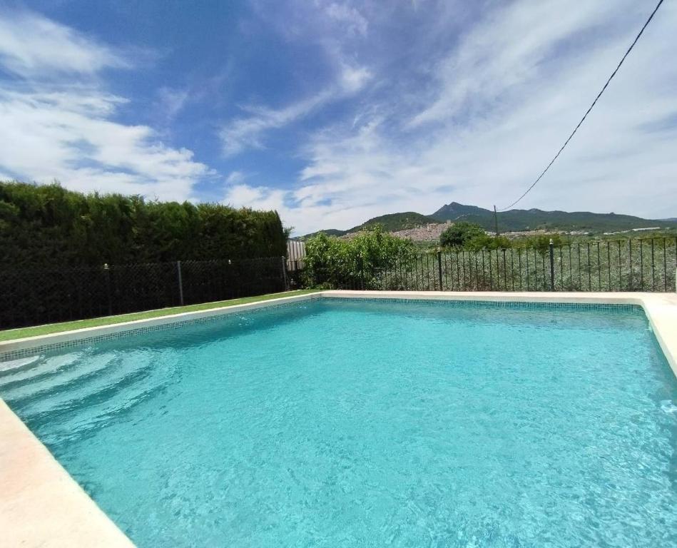a swimming pool with blue water in a yard at Casa rural miralmonte in Moratalla