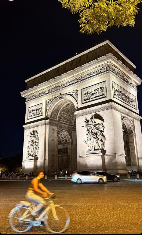 une personne faisant du vélo devant un bâtiment dans l'établissement Fabulous Paris F2 Champs-Elysées, à Paris