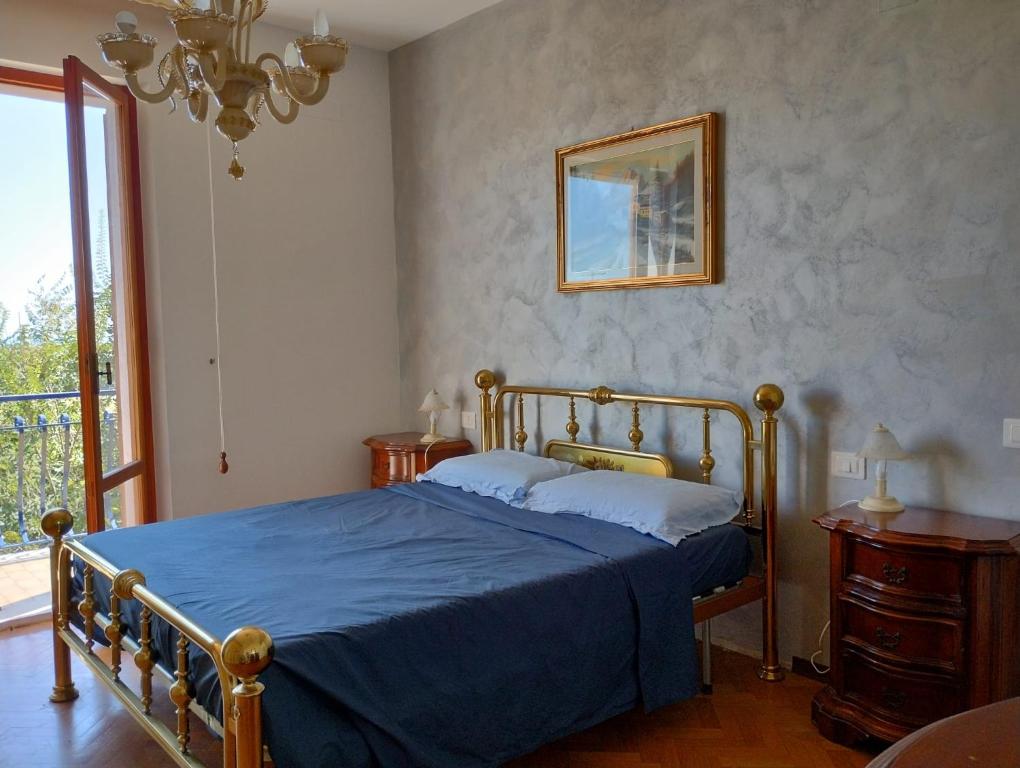 a bedroom with a bed with a blue comforter at L'Orizzonte in Castelfidardo
