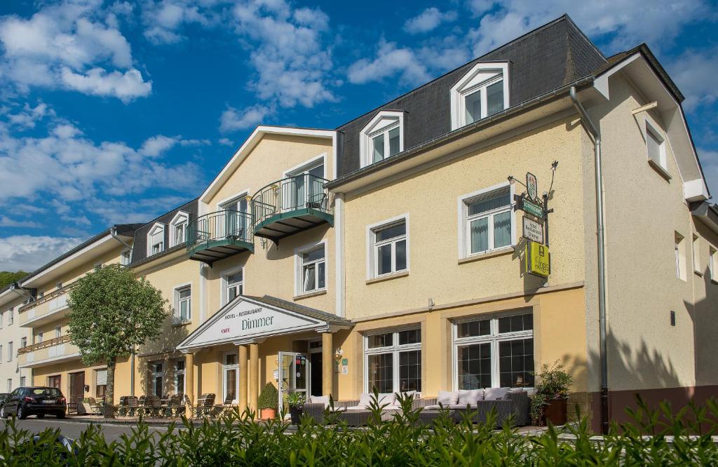 un grand bâtiment jaune avec un toit noir dans l'établissement Hotel-Restaurant Dimmer, à Wallendorf pont