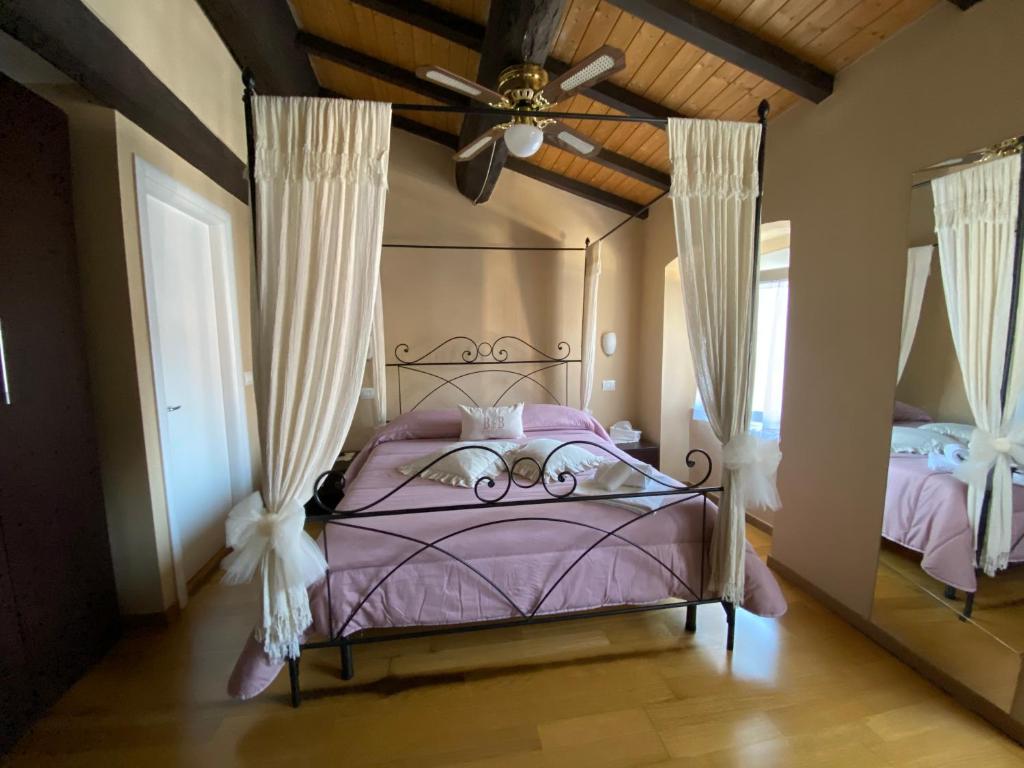 a bedroom with a purple bed with a ceiling fan at B&B in Piazzetta in Sarzana