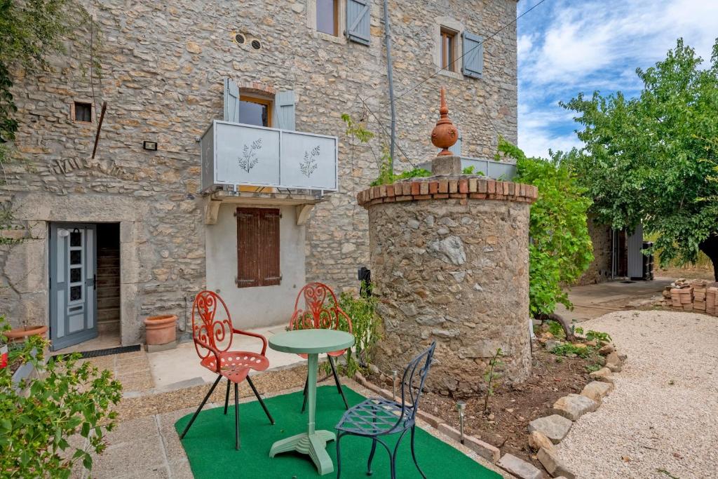 un patio avec des chaises et une table en face d'un bâtiment dans l'établissement Mazet Tornac, à Tornac