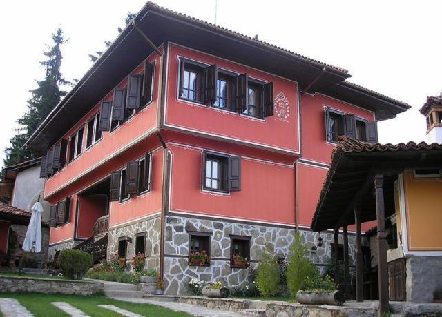 un edificio rojo con ventanas negras en Gozbarov's Guest House en Koprivshtitsa