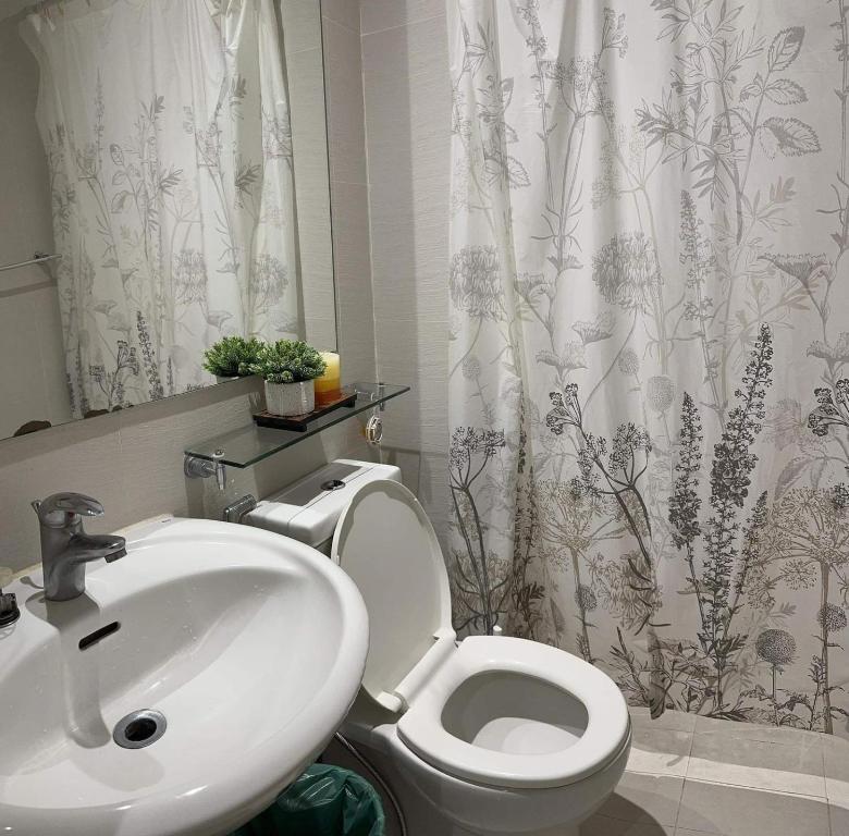 a bathroom with a white toilet and a sink at Suite M - 1 Bedroom Condo at Azure Residences in Manila