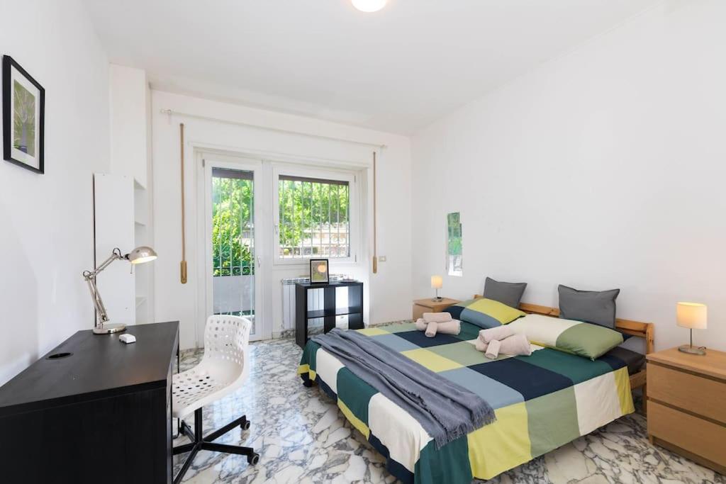 Schlafzimmer mit einem Bett, einem Schreibtisch und einem TV in der Unterkunft Spazioso appartamento vicino EUR in Rom