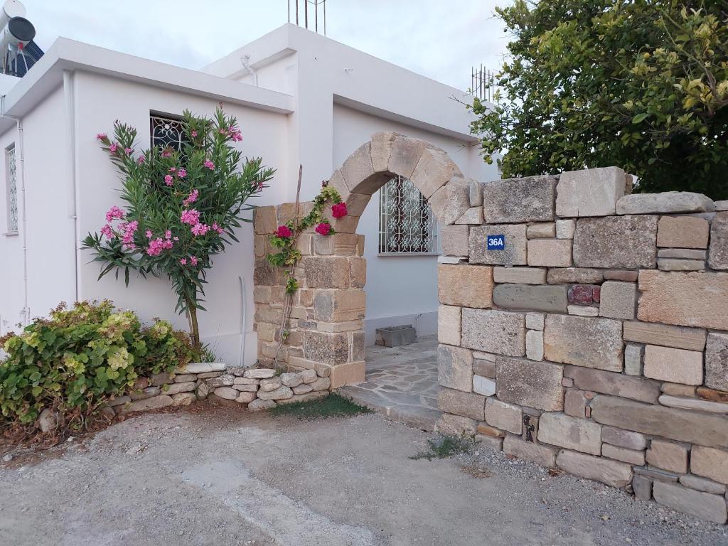 uma casa com uma parede de pedra e um arco de pedra em La Medusa Gardens em Iskele